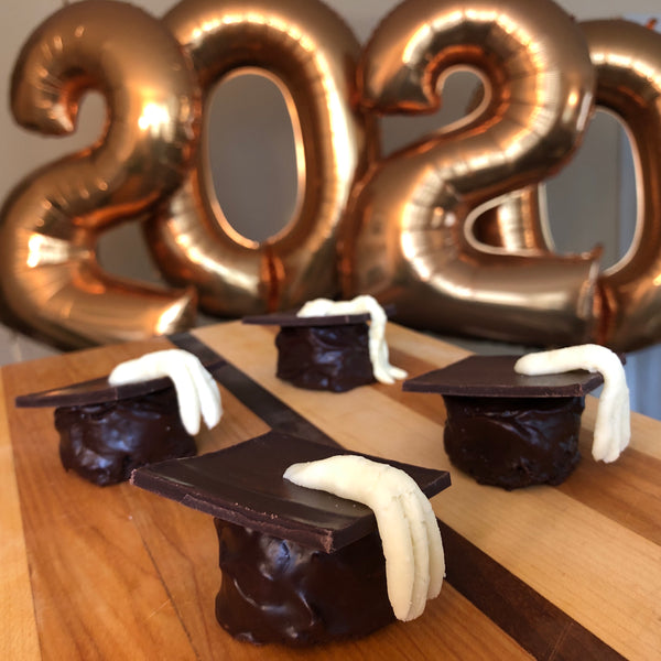 chocolate graduation caps with white chocolate tassels with giant gold balloons in the shape of