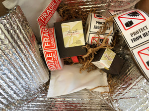 a couple small boxes of Tangle Chocolate thins surrounded by packaging materials, including ice packs, insulation, and stickers that read "FRAGILE HANDLE WITH CARE" and "PROTECT FROM HEAT"