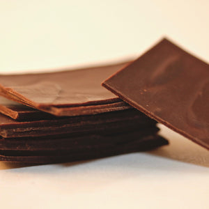 a zoomed-in photo of a stack of slivers of premium Tangle Chocolate dark chocolate thins