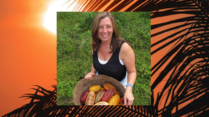 Woman smiling and holding a basket of cacao pods