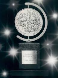 a sparkling silver Tony Award with a round, embossed silver icon atop a black base