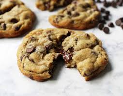 a melty chocolate chip cookie sitting on a white countertop