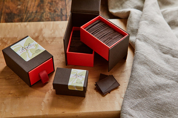 three differently-sized boxes of Tangle Chocolate premium 9-calorie thins of dark chocolate packaged in unique red and brown boxes.